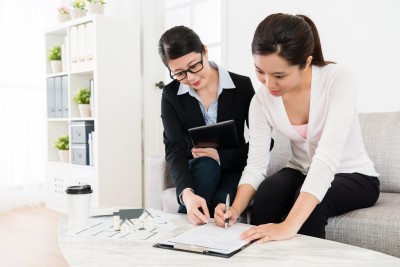 business women assisting client buying house