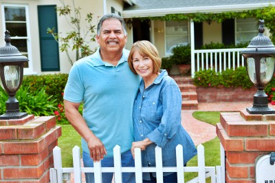 senior couple outside home smiling